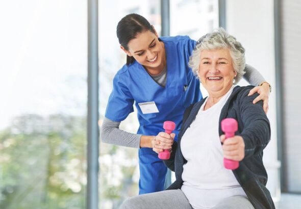 Therapist helping woman with gray hair to exercise