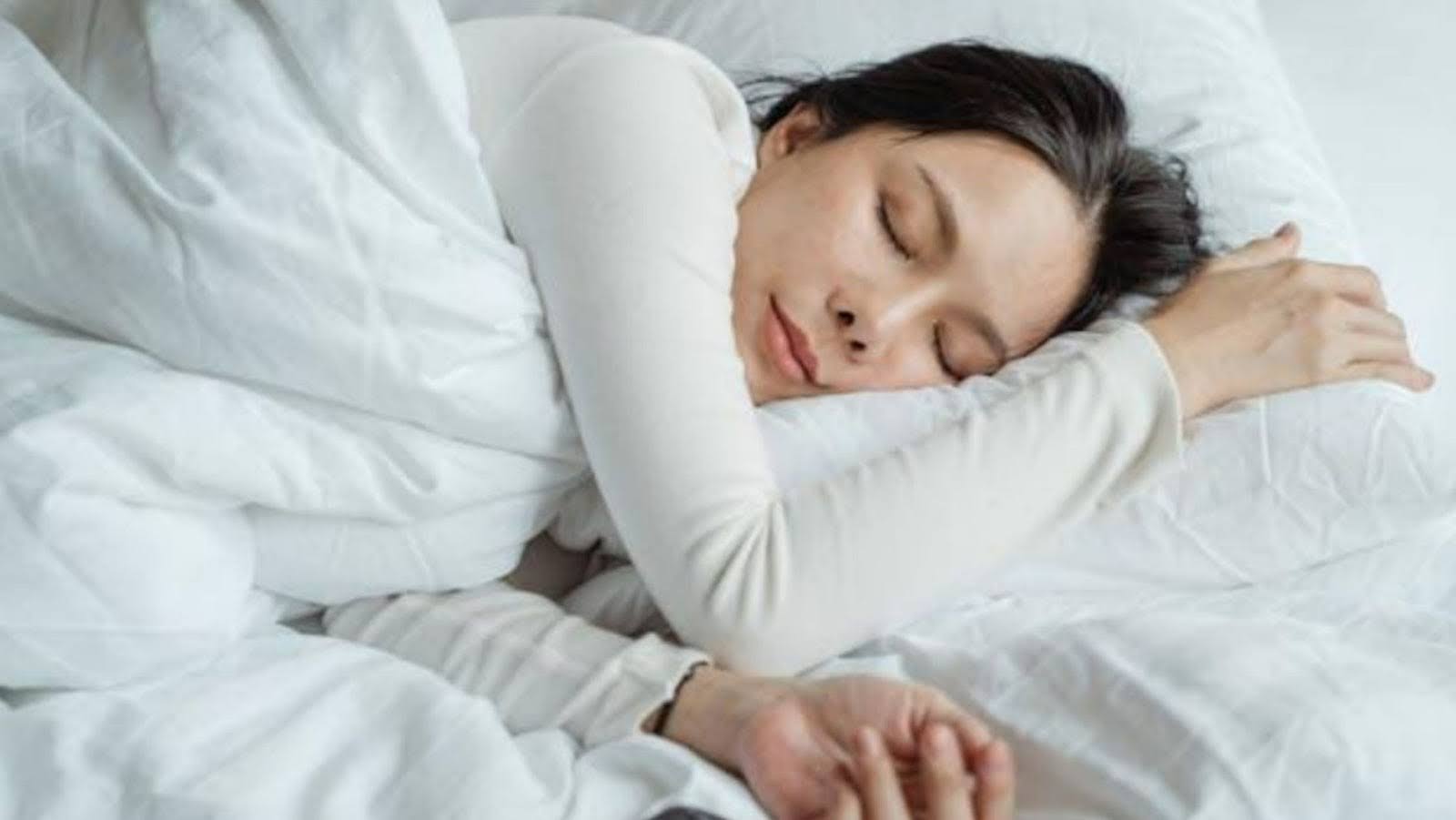 A woman waking up to her alarm clock