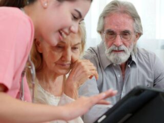 A young adult nurse working with an elderly couple who are learning how to find old medical records in California.