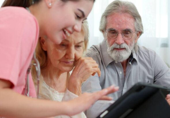 A young adult nurse working with an elderly couple who are learning how to find old medical records in California.