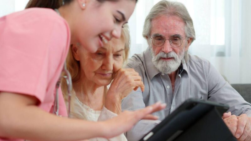 A young adult nurse working with an elderly couple who are learning how to find old medical records in California.