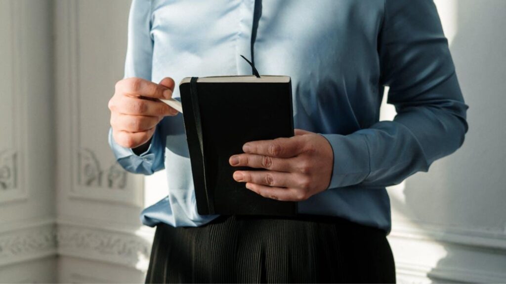 A close-up of a woman holding a notebook during a patient session