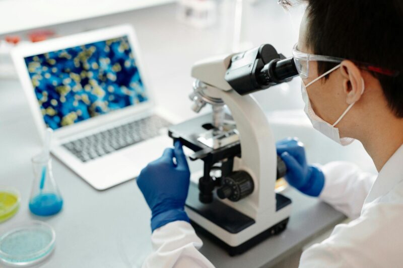 researcher looking through microscope